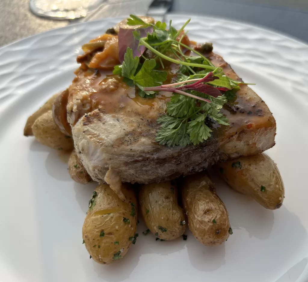 Image of a roasted piece of swordfish on top of roasted fingerling potatoes from the Coastal Prime restaurant
