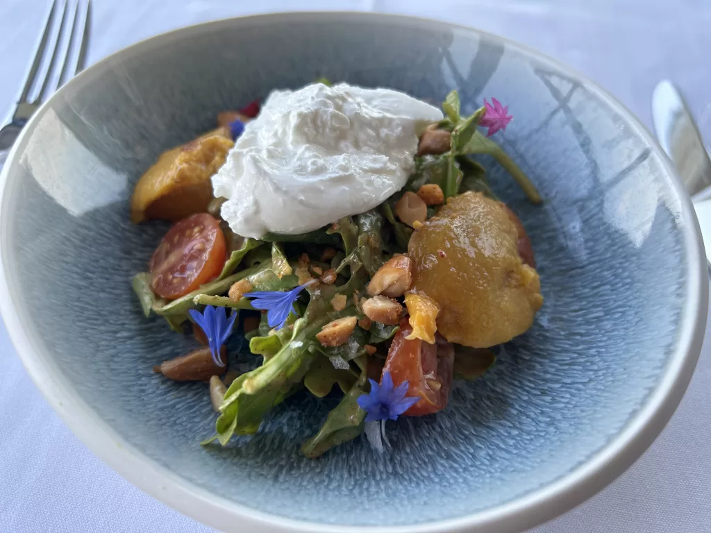 Salad with blue and pink flower garnish in a bowl