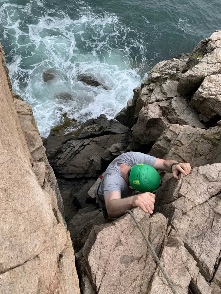 Man climbing coastal cliffs